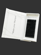 Open white lash extension tray displaying neatly organized black lashes, with a clear protective lid and 'Make your Marque' printed in elegant script on the packaging.